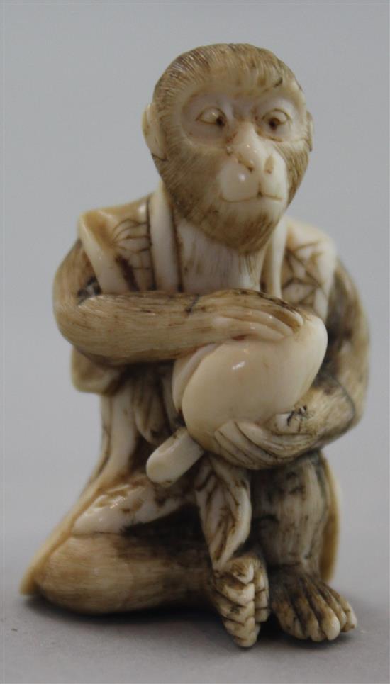 A Japanese ivory netsuke of a seated monkey holding a peach, signed Kogetsu, Meiji period, 3.8cm